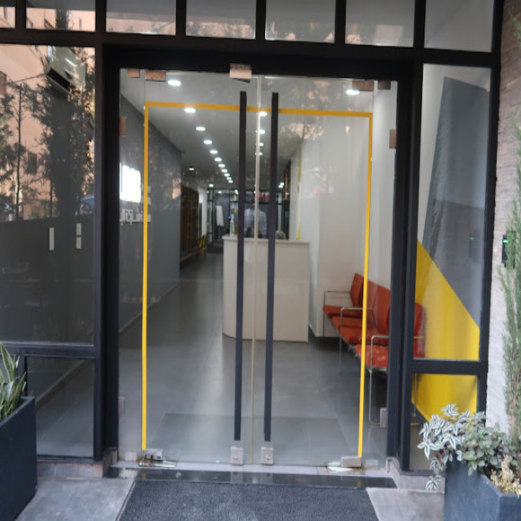 Glass doors to an ecommerce marketing company office. Modern interior with seating.